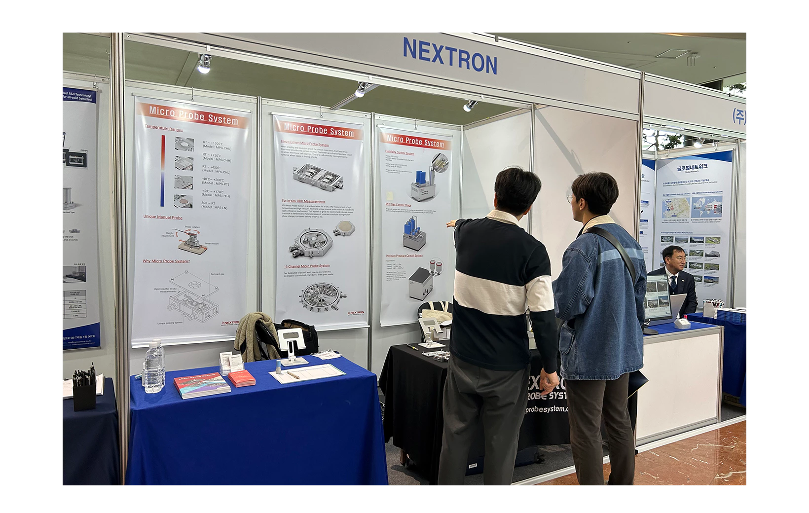Research director pointing to a banner and explaining at the 2023 Spring Meeting & Academic Presentation of the Korean Electrochemical Society