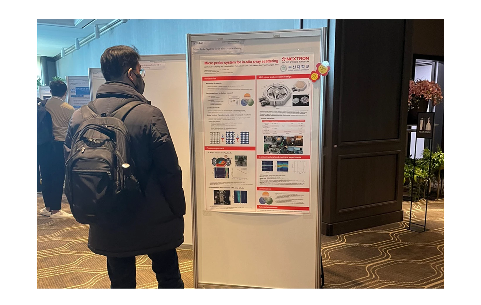A person looking at Nextron's presentation poster at the 2023 Spring Meeting of the Korean Ceramic Society