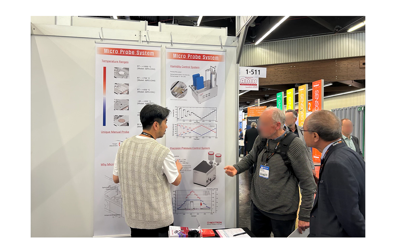 Research director pointing to banner at 2023 SMSI and explaining to customer who asks questions