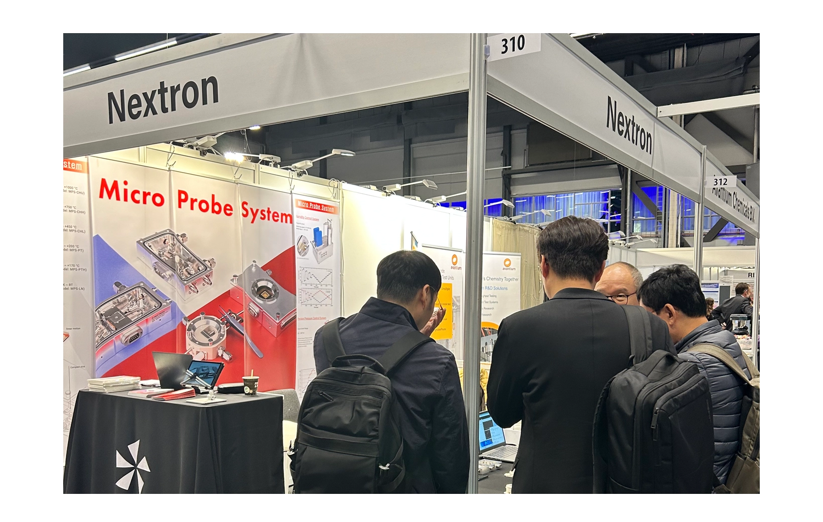 The branch manager explaining things to people gathered at Nextron’s promotional booth at the 2023 ECS